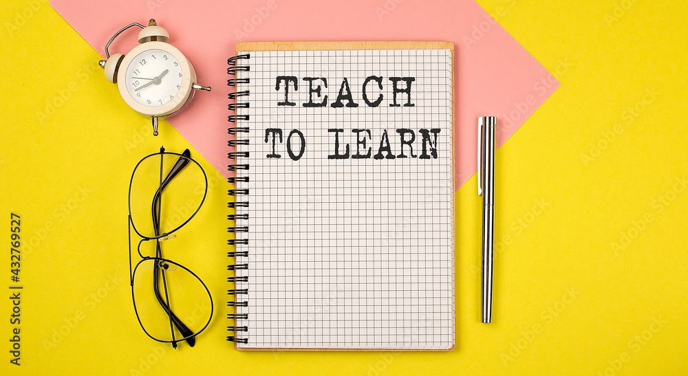 Poster teach to learn text on the notebook with pen on yellow background with pen, glasses and alarm cloack