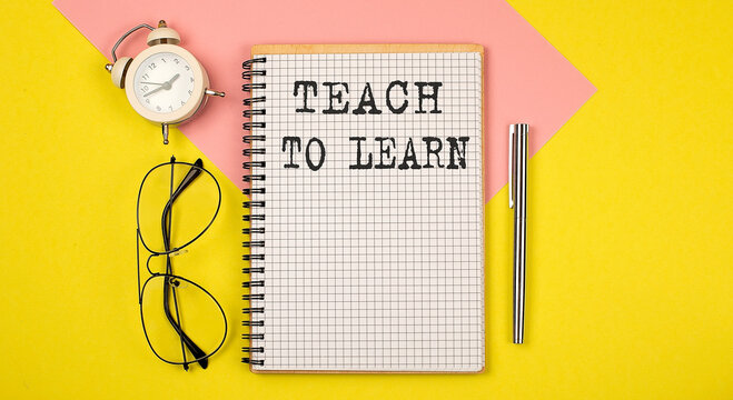 TEACH TO LEARN text on the notebook with pen on yellow background with pen, glasses and alarm cloack