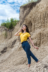 Naklejka na ściany i meble Pretty woman poses against sand canyon background of rocks