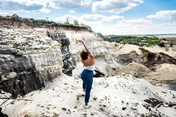 young woman doing light exercises in a sand quarry. yoga. relaxation in nature