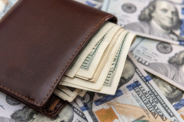 Dollars banknotes in a dark leather wallet