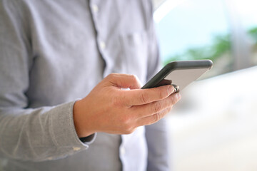 Close up view of businessman browsing or texting using his mobile phone.. Copy space.