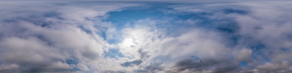 Fototapeta premium Blue evening sky seamless panorama spherical equirectangular 360 degree view with Cumulus clouds, setting sun. Full zenith for use in 3D graphics, game and aerial drone panoramas as sky replacement.