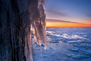 Ice sculpture mooring post during sunset in winter at the Afsluitdijk in The Netherlands