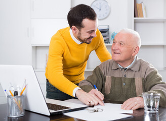 Aged man signing financial agreement in office with manager