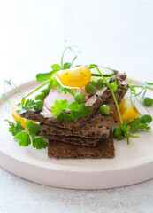 Healthy rye bread with raw spring vegetables close up