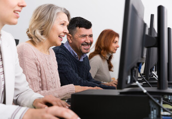 Obraz premium Side view of coworkers during daily work at computers in modern office