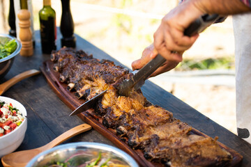 man cutting roast beef on a table