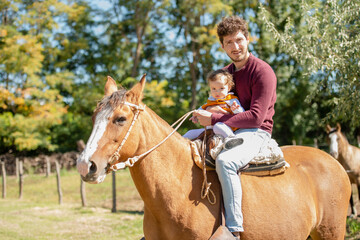 Obraz premium man riding horse with his daughter