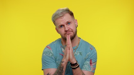 Please, God help. Trendy stylish adult guy praying, looking upward and making wish asking with...