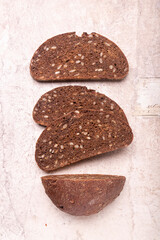 Slices of rye flour bread with seeds and nuts. On vintage paper.