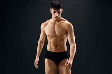 handsome sporty man with naked muscled body dark panties studio