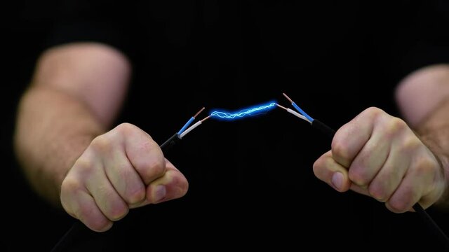 Man holds an electric wire.
Electrical spark between copper wires 