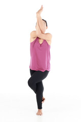 Full length portrait of a smiling happy asian lady in casual clothes practicing yoga by standing in basic lesson on white background. Healthy life and mind development concept.