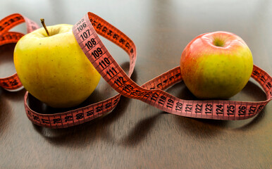   apples, meter tape.  Fitness accessories. Measuring tape, centimeter.  The concept of joint sports, Healthy way of life.