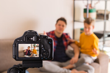 Vlogger family recording social media video while sitting on couch