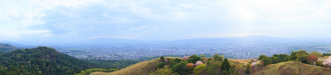 Fototapeta na wymiar Aerial view of Nara city from Mount Wakakusa (Wakakusa-yama) during spring, Panoramic view - 若草山 山頂展望台からの眺望 桜の花 パノラマ