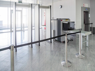 Metal detector frame and X-ray machine for checking luggage and hand baggage at entrance to public building. Checkpoint with security and anti-terrorist measures. - 432784371
