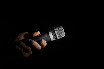 a man holding a microphone on a black background