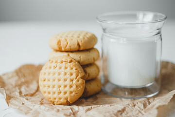 Delicious homemade peanut butter cookies with mug of milk, on white background. Healthy breakfast concept.