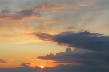 Fototapeta na wymiar Beautiful black clouds in the sky at orange sunset, natural background