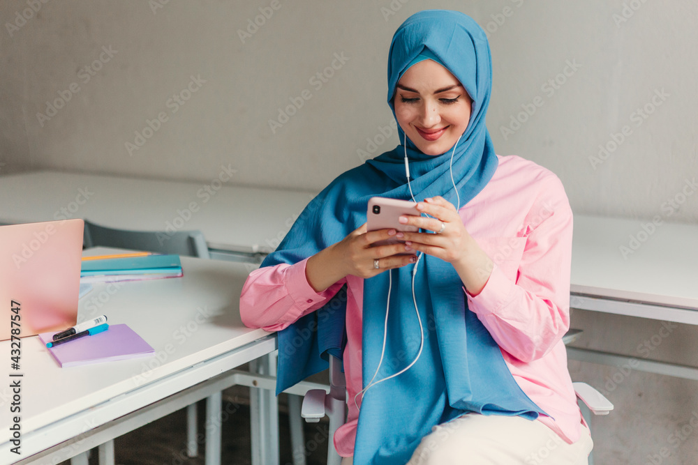 Wall mural muslim woman in hijab working in office room