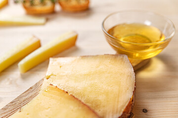 photo of slices of a typical Italian hard grain cheese, arranged on a wooden cutting board, with walnuts, croutons, honey and herbs. HD image for magazines, sites, social networks, web sites, post-pro