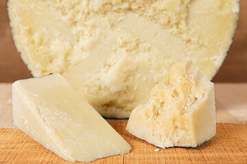 typical Italian cheese: salted pecorino romano, on a wooden cutting board, walnuts, honey, dried...