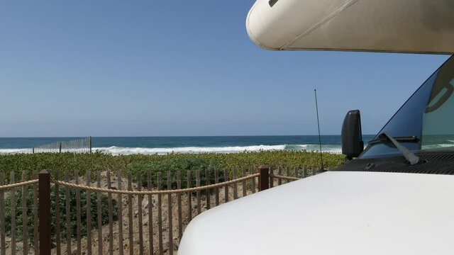 Motorhome trailer, caravan for road trip. Waterfront Encinitas, waves of pacific ocean sea beach, California coast USA. Beachfront vacations, camper van RV motor home. Mobile home campervan. Blue sky.