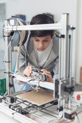 Young student using a 3D printer in the lab