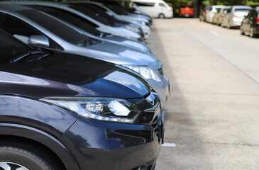 Closeup of front side of dark blue car with  other cars parking in parking area.