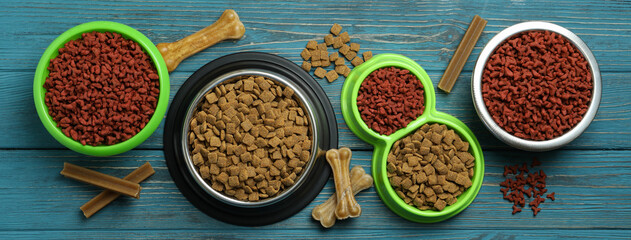 Bowls with pet feed on wooden background