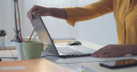 Woman sitting at desk and using her laptop