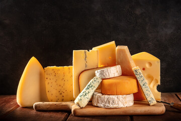 Cheese variety on dark rustic backgrounds. Soft and hard cheeses