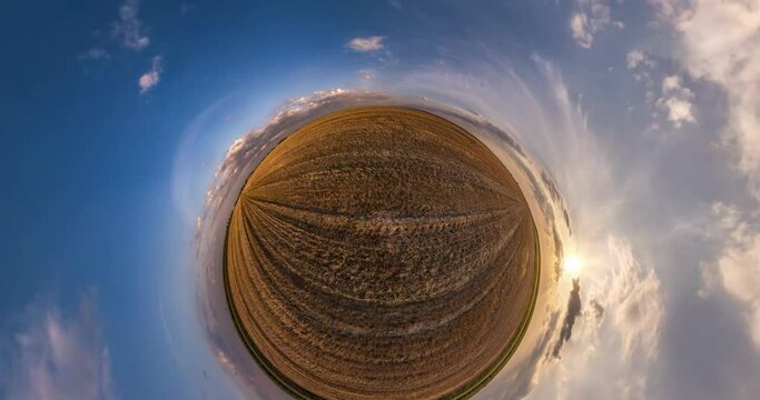 little planet transformation with curvature of space. Abstract rotate, torsion and spinning full panorama among fields in evening with beautiful clouds