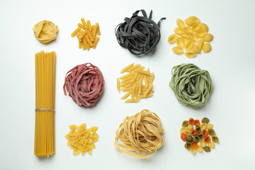 Different uncooked color pasta on white background