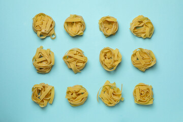 Flat lay with uncooked pasta on blue background