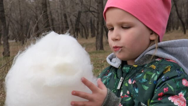 Child girl eating cotton candy