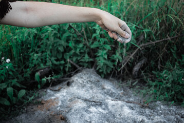 Obraz premium Young woman holding ashes near forest, ashes in hand close-up, tribal shaman near ashes. performing ancient ritual, wildfire concept, natural disaster concept