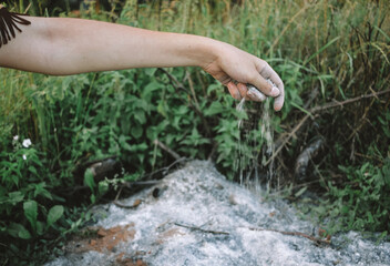 Young woman holding ashes near forest, ashes in hand close-up, tribal shaman near ashes. performing ancient ritual, wildfire concept, natural disaster concept