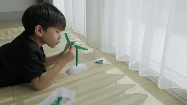 Asian boy playing solar cell toy. Building stem fundamental learning for 5 years old kid.