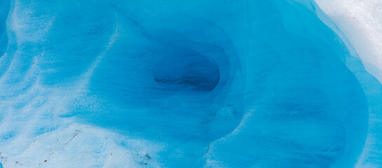 Close up in panorama format of the melting blue ice of a tongue of the Svartisen glacier, Holandsfjord, Nordland, Norway