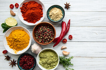 Various spices  on white wooden background, top view