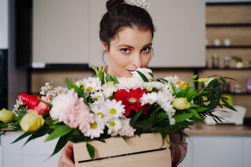 Close up portrait Caucasian woman enjoying flowers aroma. Woman's day flower bouquet. Beautiful woman face