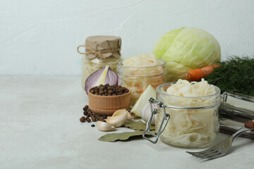 Fresh sauerkraut and ingredients on white textured table