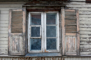 A window with open shutters in an old wooden house