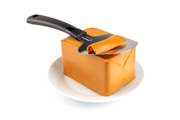 Norwegian brown cheese with cheese cutter on a plate, isolated on white background, horizontal