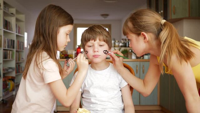 Children stay at home girls painting face to little brother boy