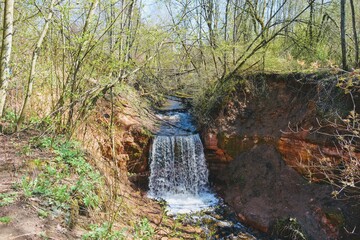 Waterfall with slight rainbow and blue sky
