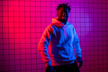 Portrait of an African American man in a hoodie on a neon background. Red-blue background.